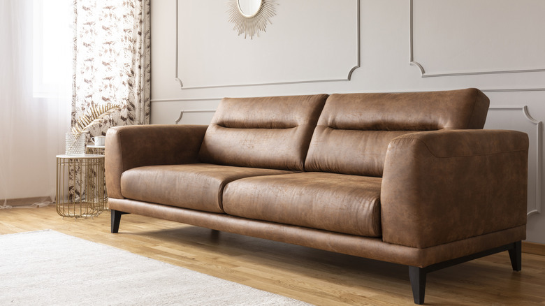 A brown leather sofa sitting in a beige living room