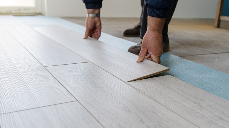 Person laying vinyl plank flooring