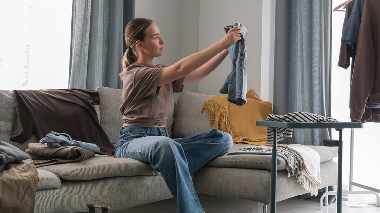Woman looking at jean shorts while decluttering clothes