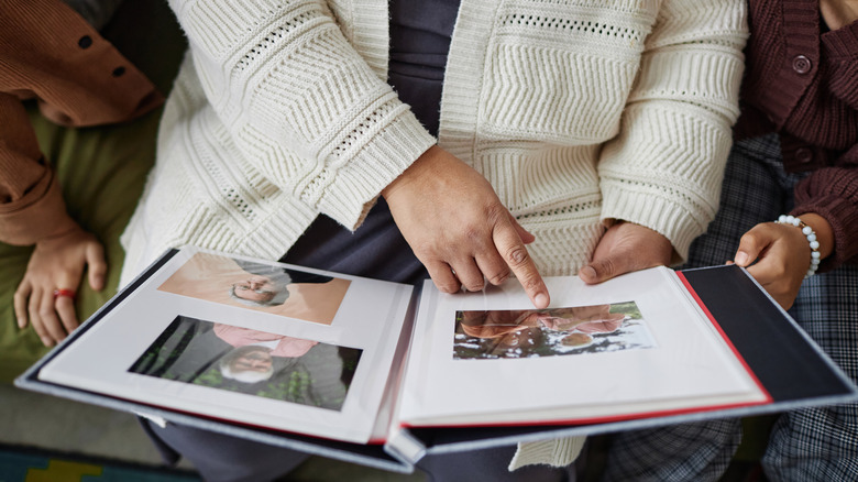 Woman looking at old family photos in an album