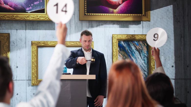 People bidding on art pieces at an auction