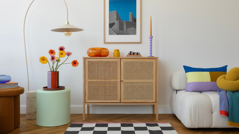 A genuine rattan dresser styled in a colorful living room with hardwood flooring and a white wall