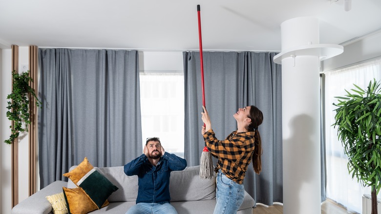 neighbors hitting broom on ceiling