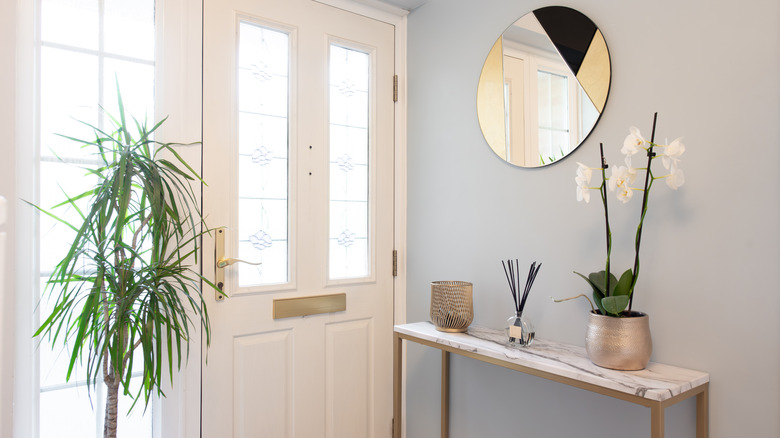 A mirror and a table in an entryway