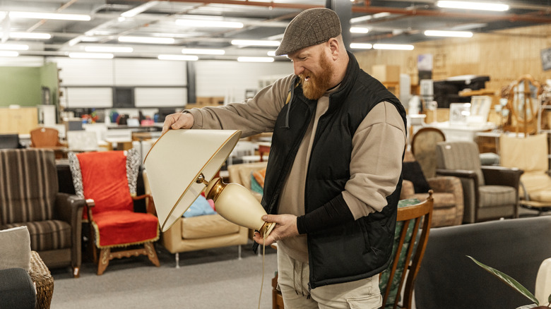 Man holding lamp at indoor flea market