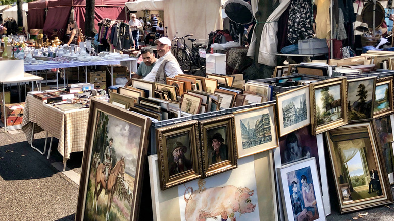 Outdoor flea market with inventory on tables and ground