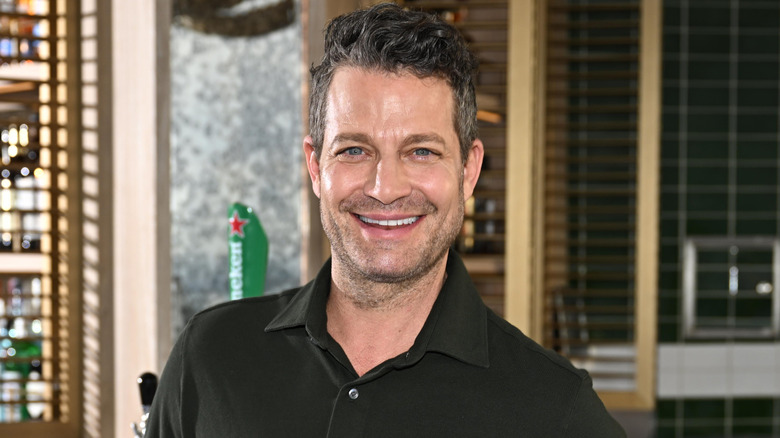 HGTV host Nate Berkus stands in front of a bar.