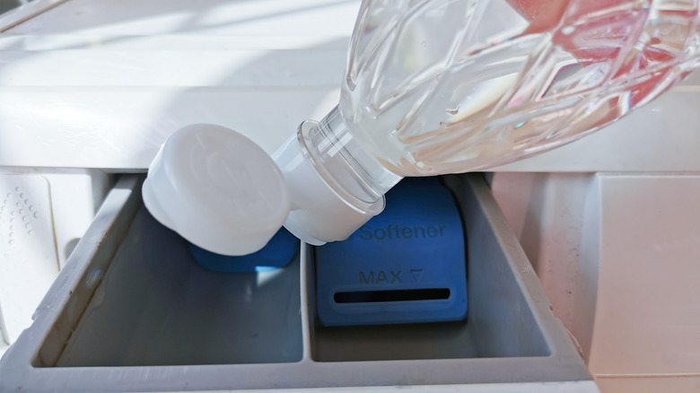 Adding white vinegar to a washing machine compartment