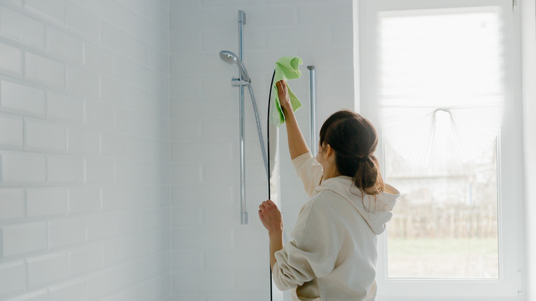 woman cleaning glass shower door