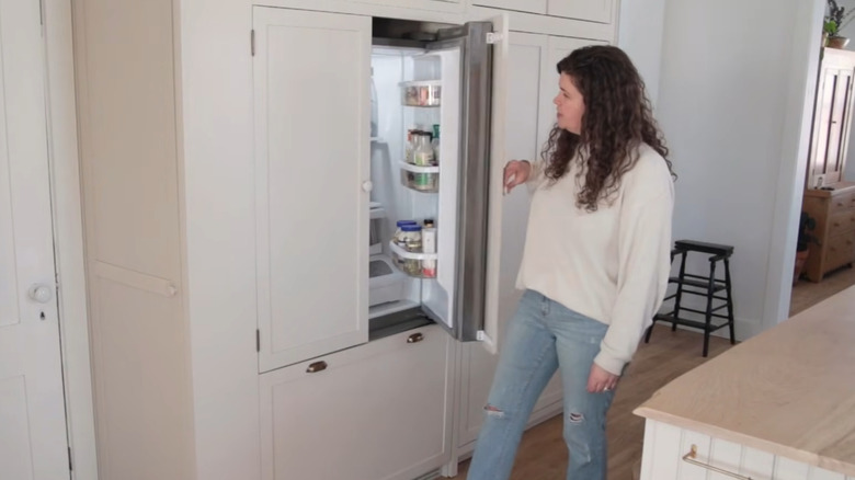 woman opening paneled kitchen fridge