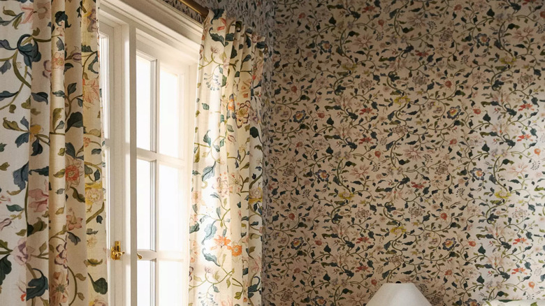 Busy patterned drapes with flower pattern that match the wallpaper