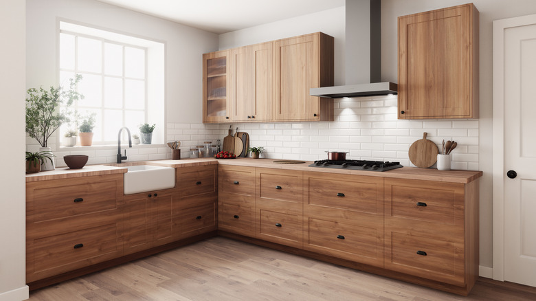 A stylish kitchen with natural wood cabinets, farmhouse sink, and white subway tile backsplash