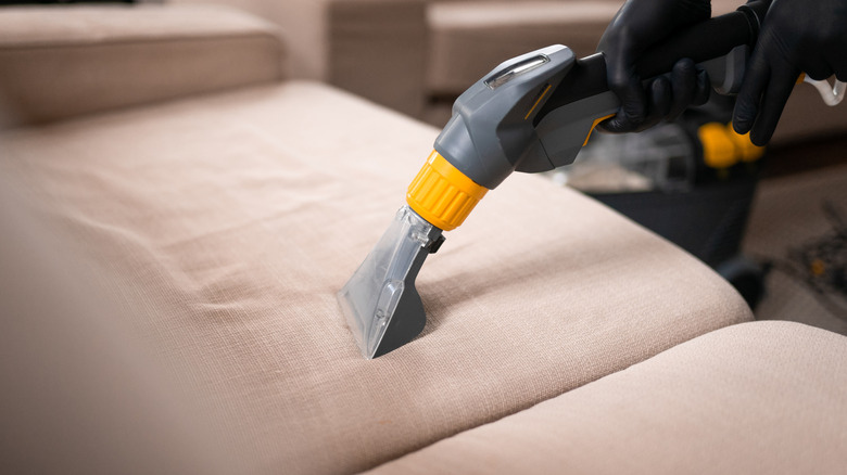 Person vacuuming a couch