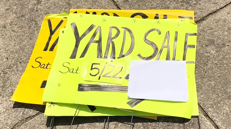 Bright yellow garage sale signs on the ground