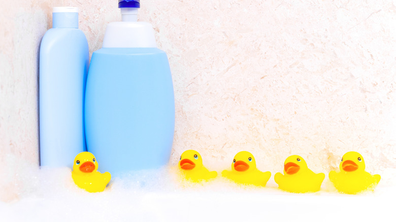 Soap bottles and rubber duckies on side of tub