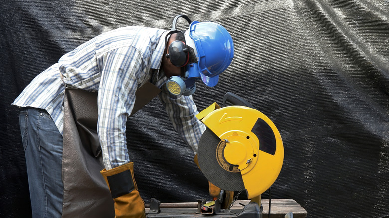 Wearing PPE cutting wood