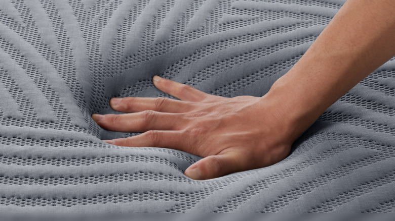 Hand pressing on the SweetNight CoolNest Mattress