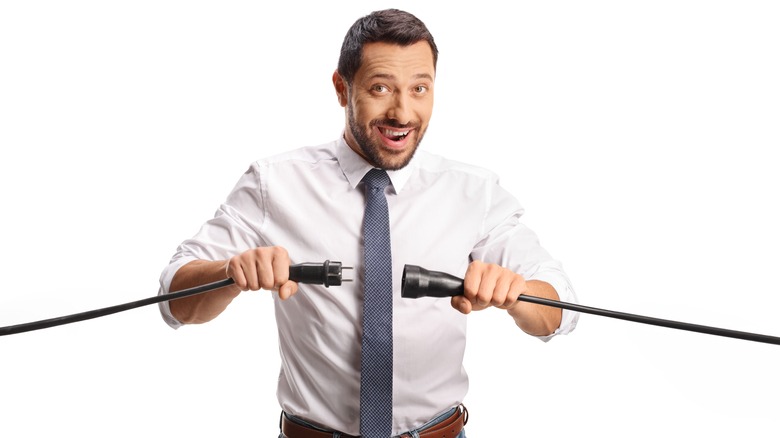 Man holding large black plug