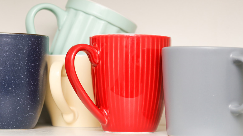 A cabinet with a collection of mismatched mugs