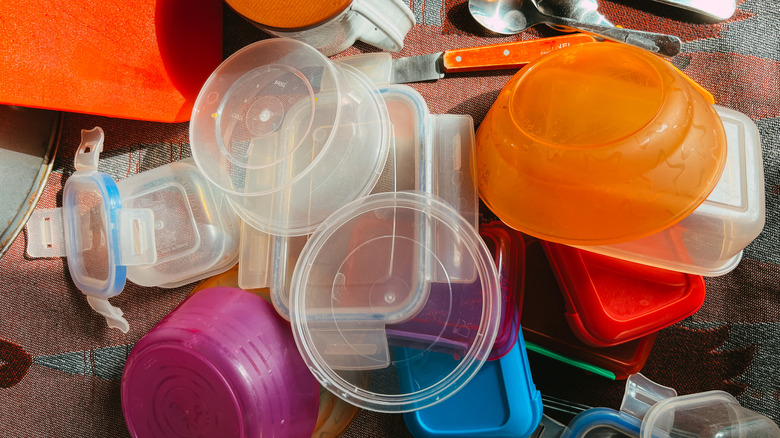 Pile of plastic food containers and lids.