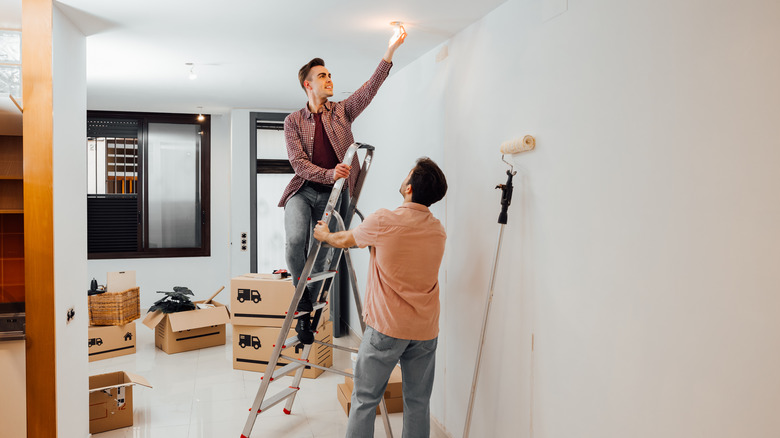 Two people changing a lightbulb