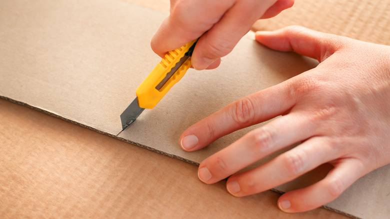 A person using a utility knife