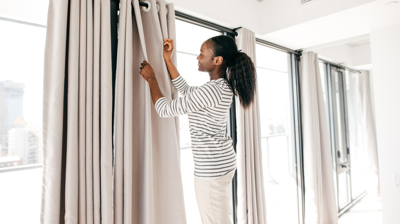 woman hanging windows at home