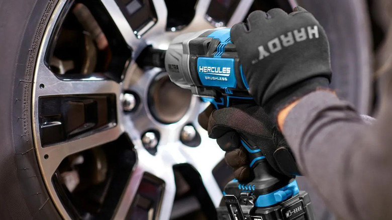 A gloved hand using a Hercules impact driver to secure lug nuts