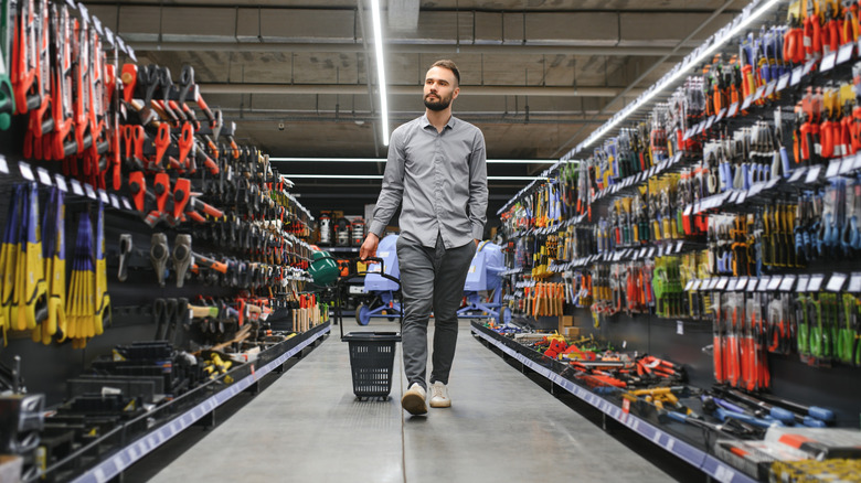A person walking down a hardware store aisle