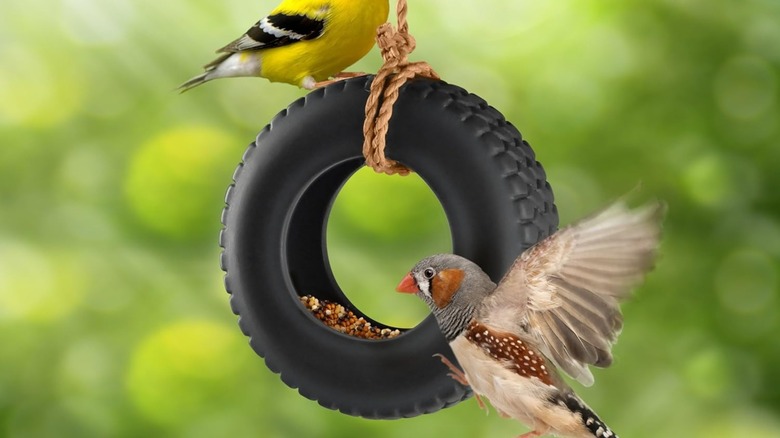 Genuine Fred Tire Swing Bird Feeder with two birds perched on it