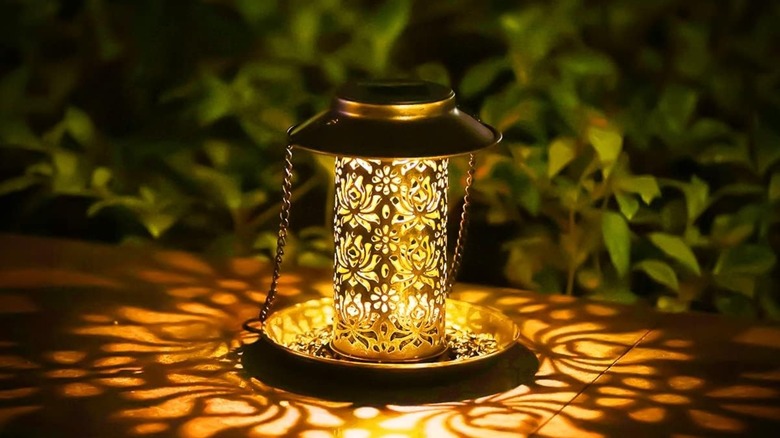 Sweetfull Solar Garden Lantern Bird Feeder illuminated on deck