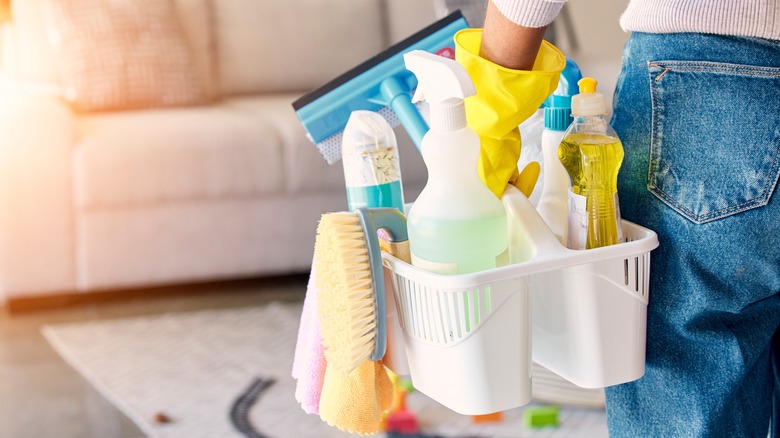 person carrying cleaning products caddy