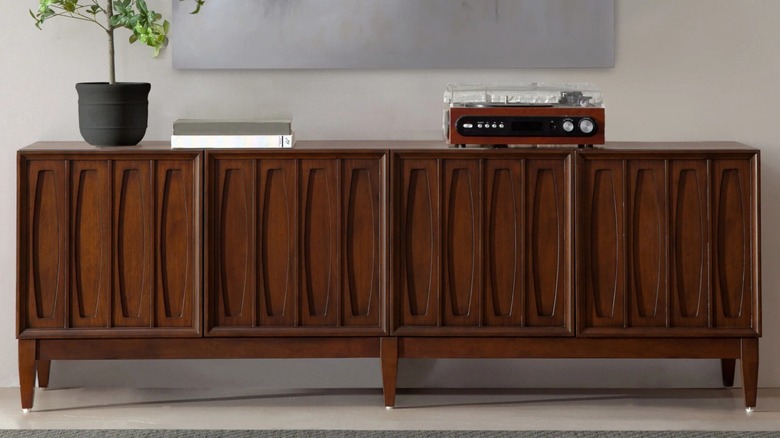 Northridge Home Monterey Bay Accent Console against wall with a plant and a record player on top of it