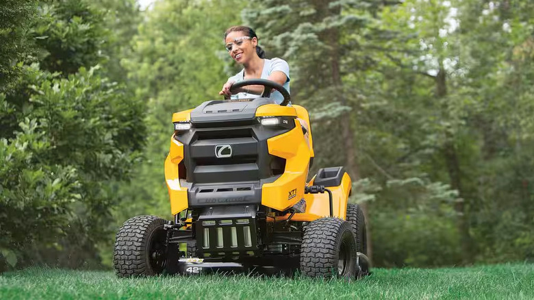 A woman mows her lawn with a Cub Cadet XT1 Enduro LT with Intelli Power Hydrostatic Drive Gas Riding Lawn Tractor