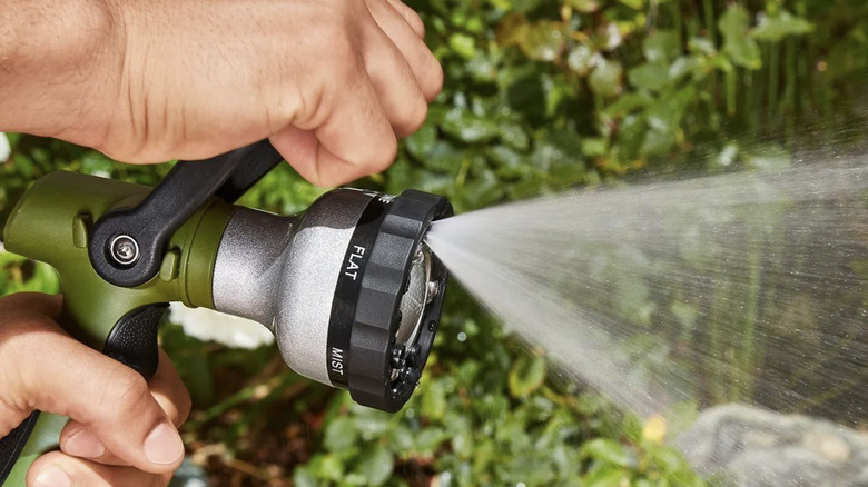 A man uses the Greenwood no-squeeze fireman's nozzle to water plants