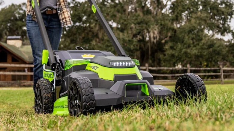 Person operating Greenworks walk-behind lawn mower