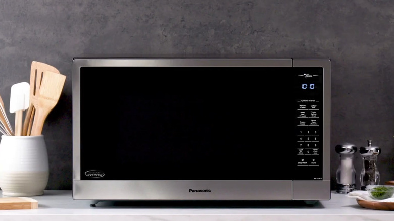 Panasonic microwave with inverter stamp on a counter with other cooking utensils