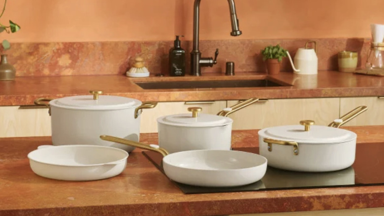 A set of pots on a counter with a stock pot, sauce pan, saute pan, frying pan, and a silicon liner
