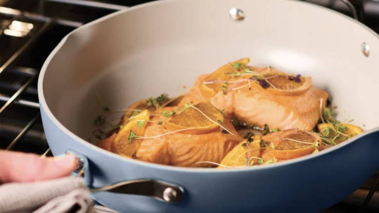 Salmon with lemon cooking in a deep frying pan