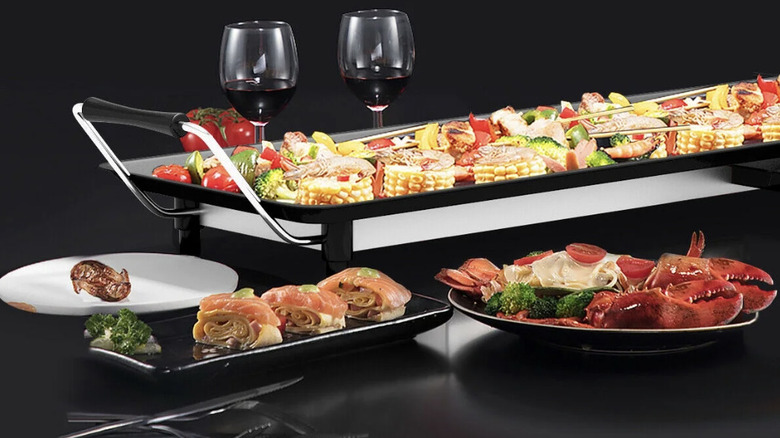 Costway Electric Teppanyaki griddle with food cooking, two wine galsses, and neatly plated seafood