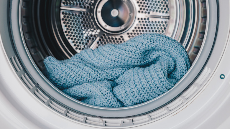 Closeup of a knitted blue blanket in a washing machine