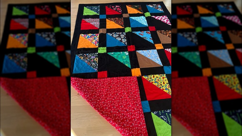 A memorial quilt is made from colorful bandanas worn by a dog.