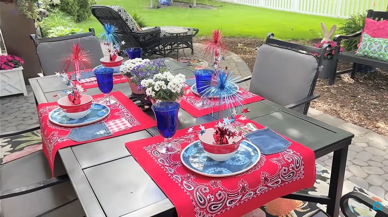 Red placemats with denim pockets decorate an outdoor table for a Fourth of July barbecue