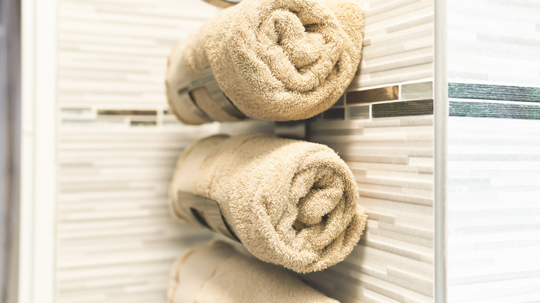 Neatly organized rolled up towels on a rack