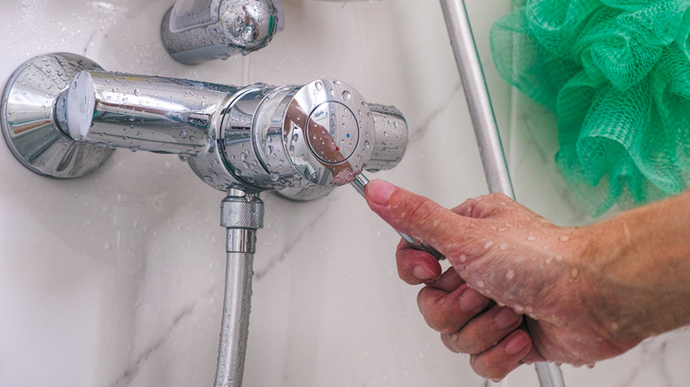 Person turns on the shower using the shower handle