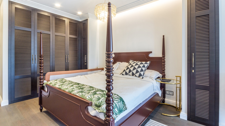 Wood four poster bed in white bedroom