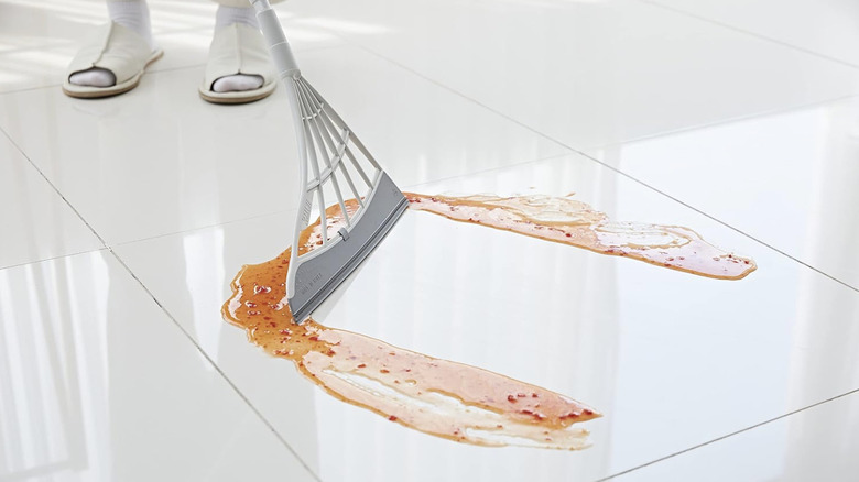 Broombi floor squeegee cleaning up a liquid spill on the ground