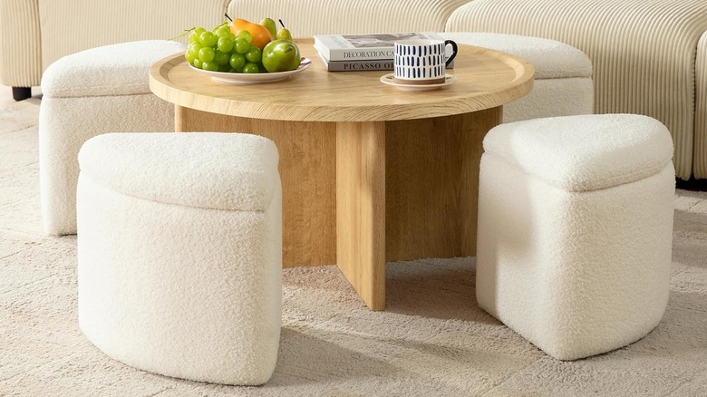 A round wooden coffee table with pull out fabric seating stools.