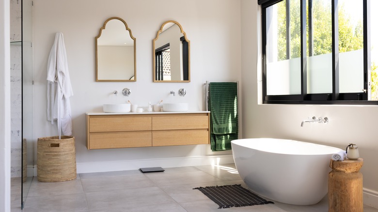Classic bathroom with double wooden vanity and freestanding tub.