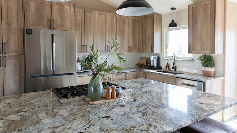 A kitchen with granite countertops and wood cabinets.